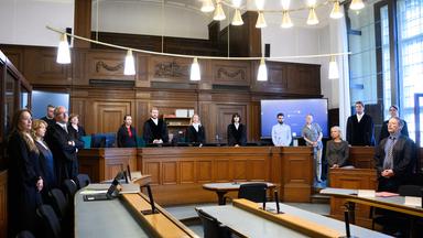 Die Prozessbeteiligten (l-r), die Rechtsanwälte des Angeklagten, Klaudia Dawidowic, Ria Halbritter und Christoph Stoll, sowie die Vorsitzende Richterin Sylvia Busch (M) und Staatsanwalt Philipp Meyhöfer (2.v.r.) stehen beim Mordprozess gegen einen Palliativarzt, der in Berlin 15 Menschen getötet haben soll, im Landgericht Berlin.
