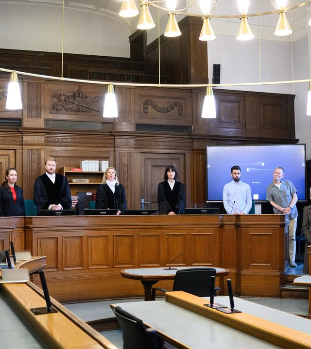 Die Prozessbeteiligten (l-r), die Rechtsanwälte des Angeklagten, Klaudia Dawidowic, Ria Halbritter und Christoph Stoll, sowie die Vorsitzende Richterin Sylvia Busch (M) und Staatsanwalt Philipp Meyhöfer (2.v.r.) stehen beim Mordprozess gegen einen Palliativarzt, der in Berlin 15 Menschen getötet haben soll, im Landgericht Berlin.