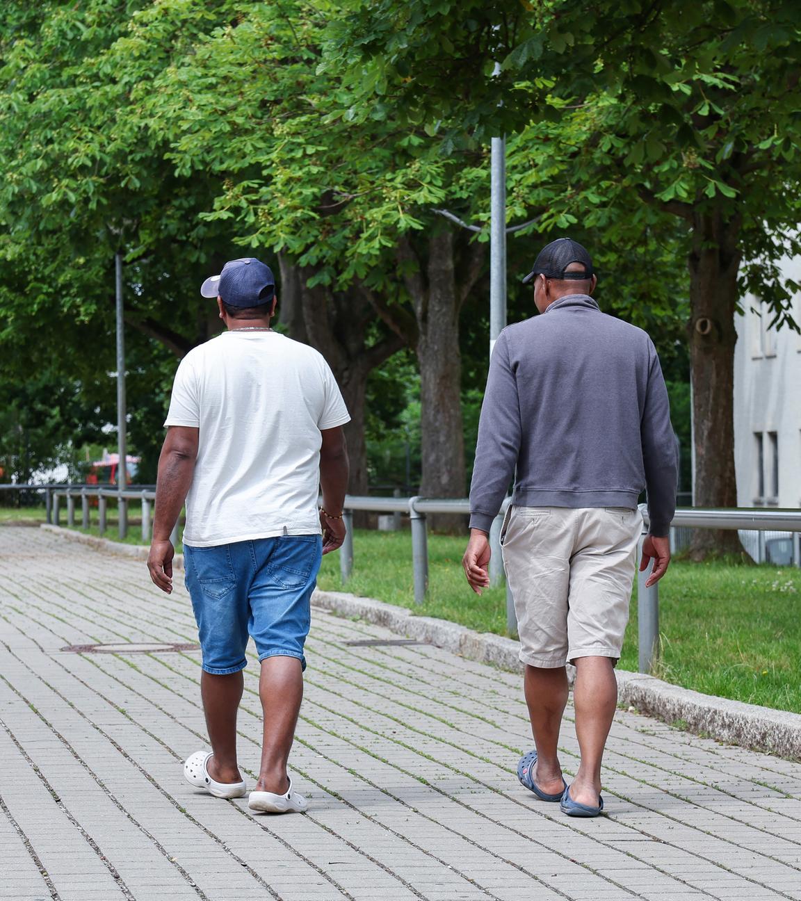 10.06.2025, Bayern, Zirndorf: Zwei Bewohner gehen in der Zentralen Aufnahmeeinrichtung für Asylbewerber in Bayern über das Gelände. 