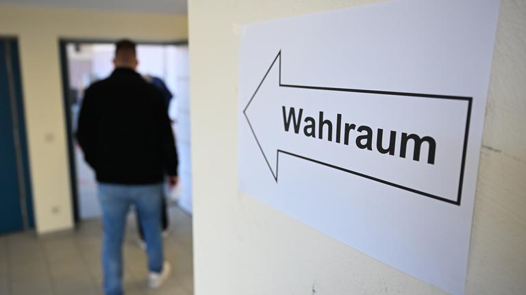 Baden-Württemberg, Weil der Stadt: Ein Mensch geht in den Wahlraum eines Wahllokals.
