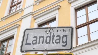 Ein Schild mit der Aufschrift "Landtag" vor einer Hauswand