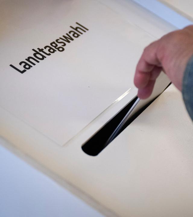 Ein Wähler wirft seinen Stimmzettel in die Wahlurne in einem Wahllokal.