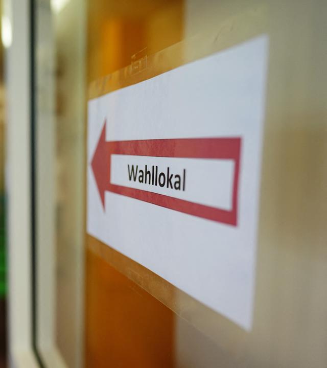 Ein Hinweisschild weist den Weg zu einem Wahllokal.