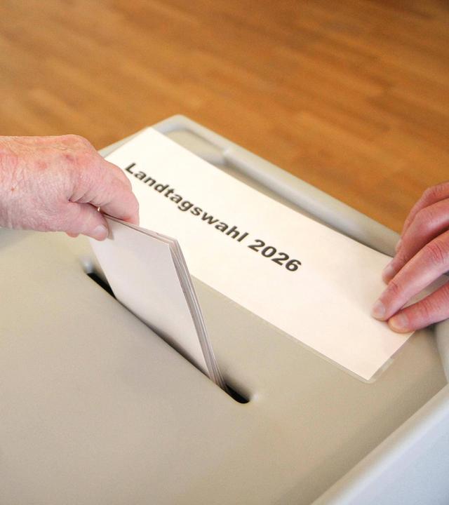 Symbolbild: Waehler wirft Wahlumschlag, Stimme in eine Wahlurne,