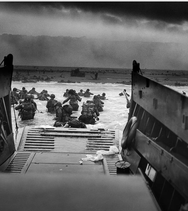 US-Soldaten und ein Landungsboot vor der Küste der Normandie 1944