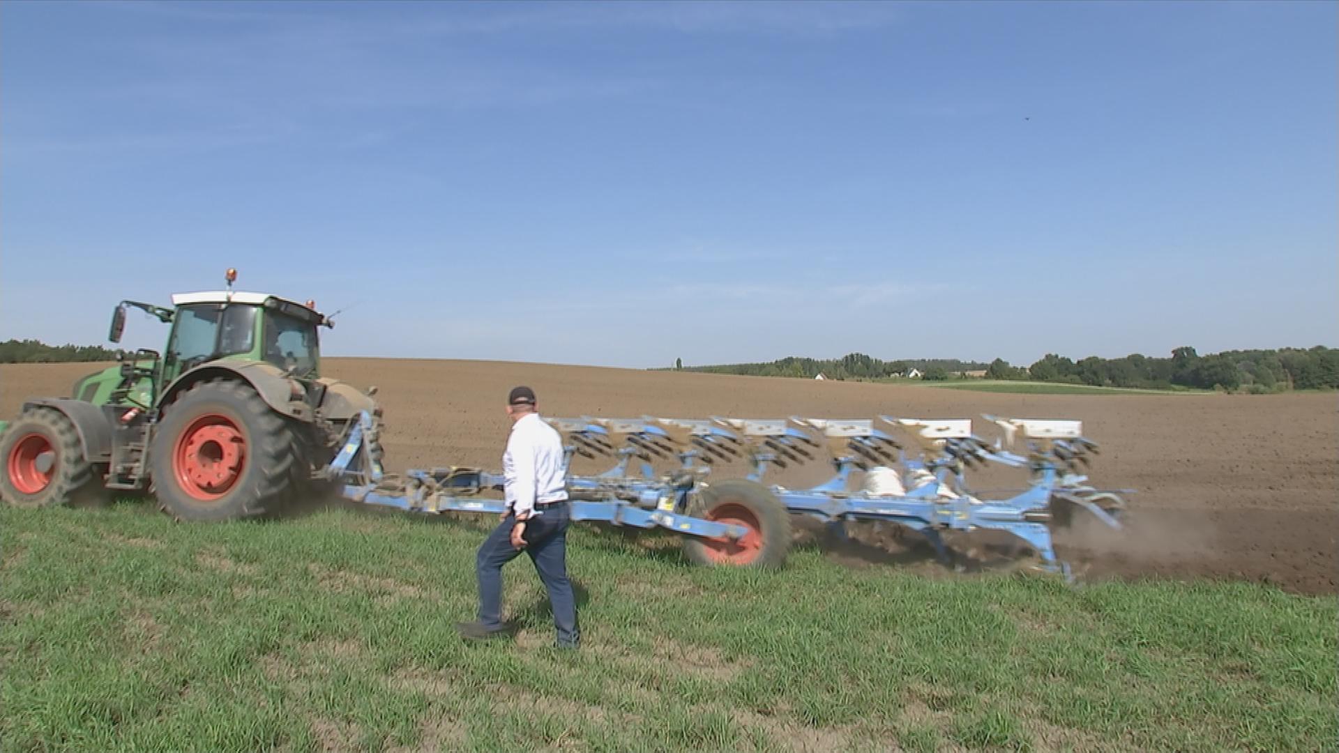 Auf dem Bild ist ein Traktor auf dem Feld zu sehen.
