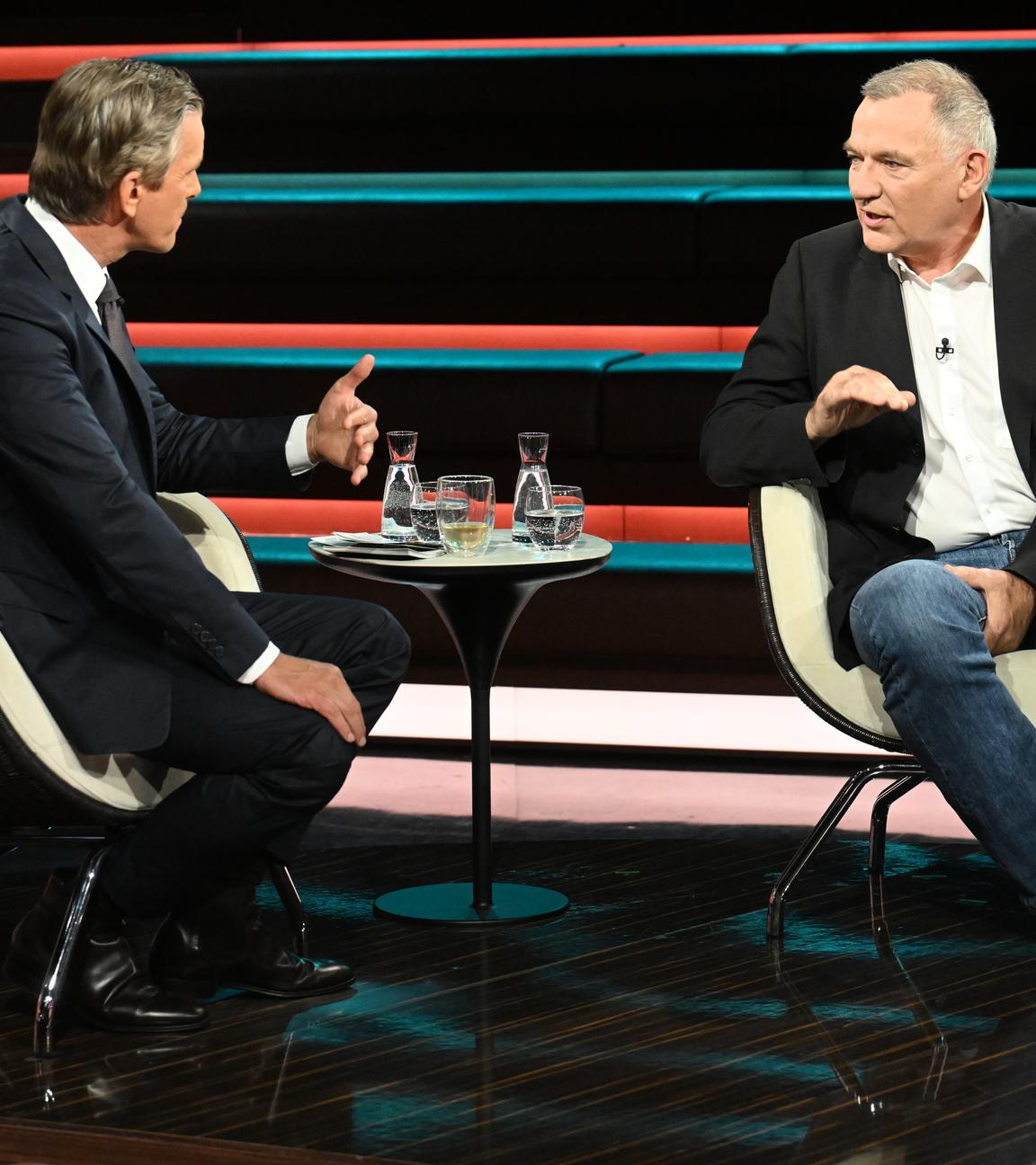 Jan van Aken in Jeans und Jackett, gestikulierend und sitzend bei Markus Lanz.