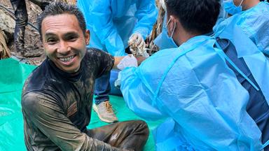 Auf diesem von der Rettungsorganisation «Metta Tham Rescue Kalasin» via AP zur Verfügung gestellten Foto ist einer der Retter (l) zu sehen, der in einer Höhle eingeschlossene Menschen befreit hat.