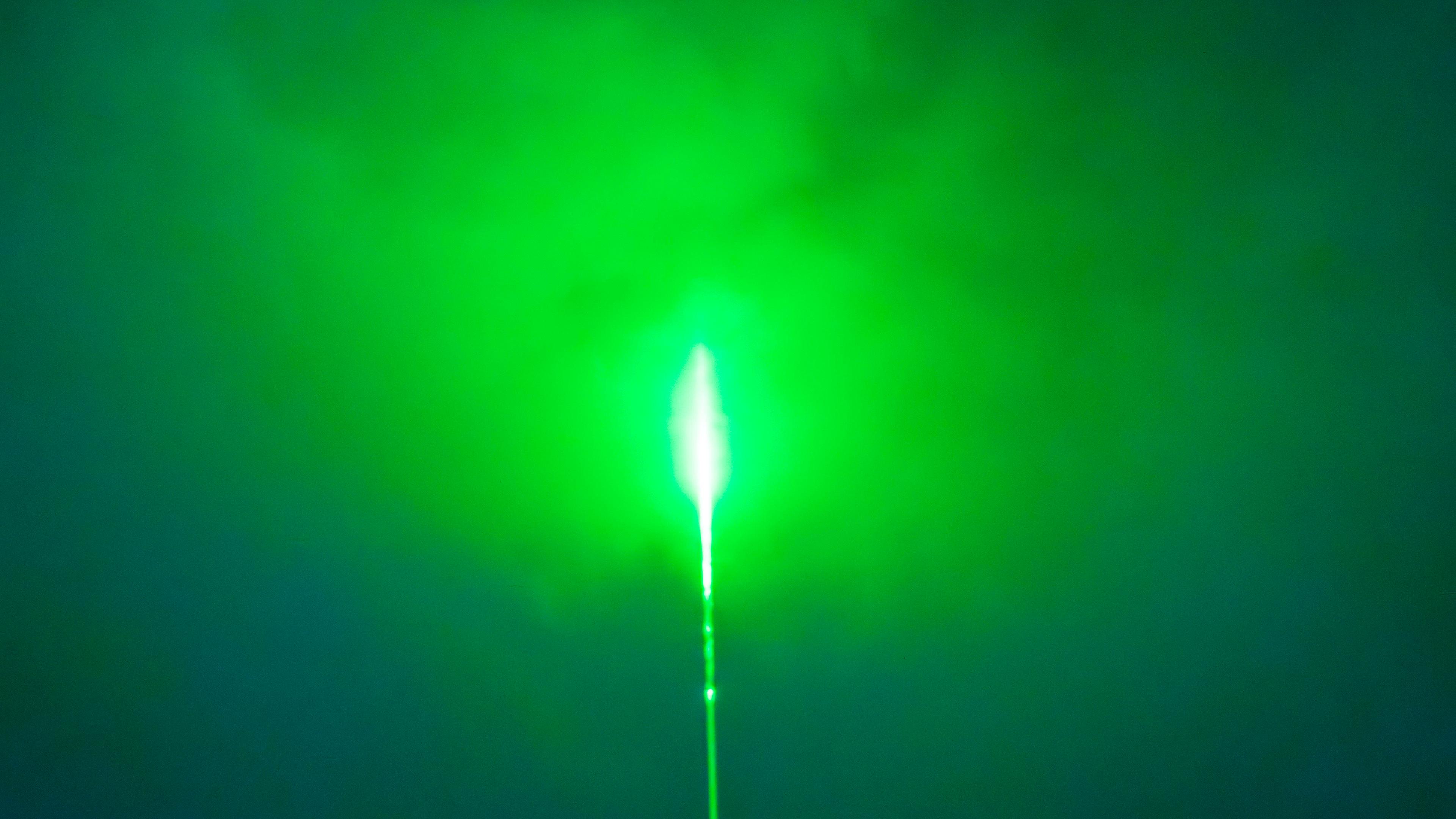 Grüner Laserstrahl am Nachthimmel über München