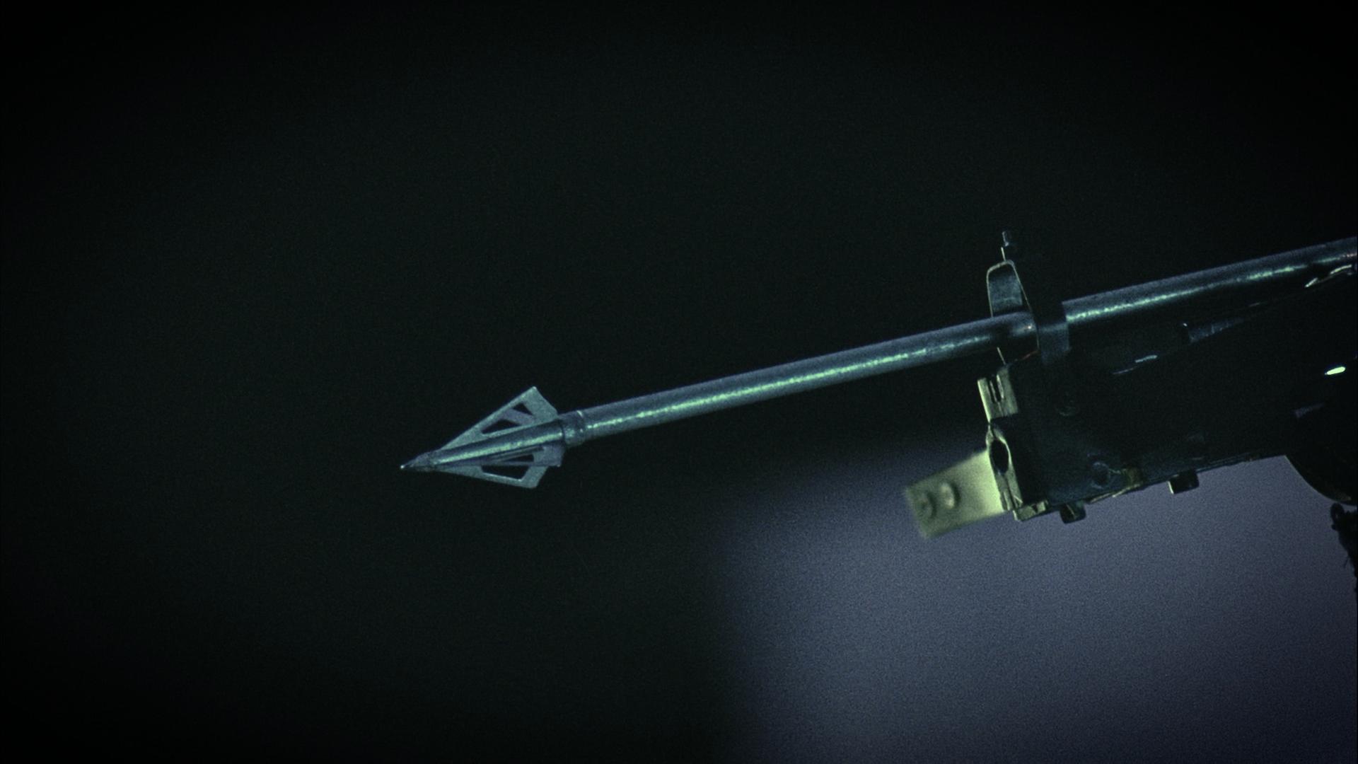 Detailaufnahme des Pfeils einer Armbrust vor dunklem Hintergrund