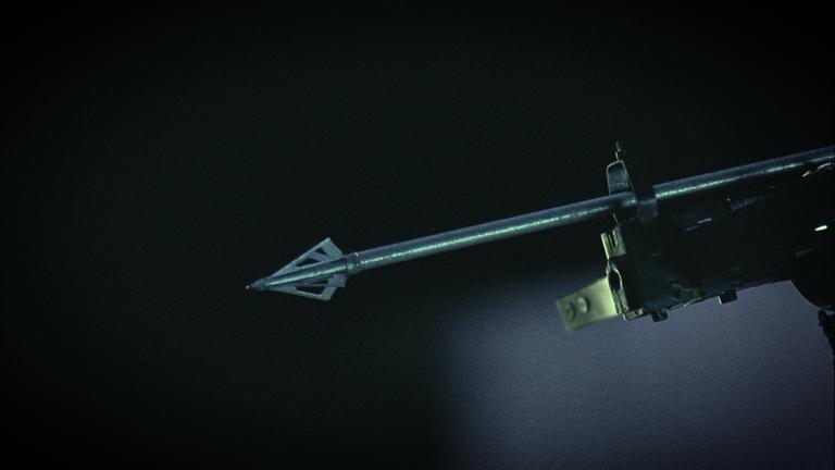 Detailaufnahme des Pfeils einer Armbrust vor dunklem Hintergrund