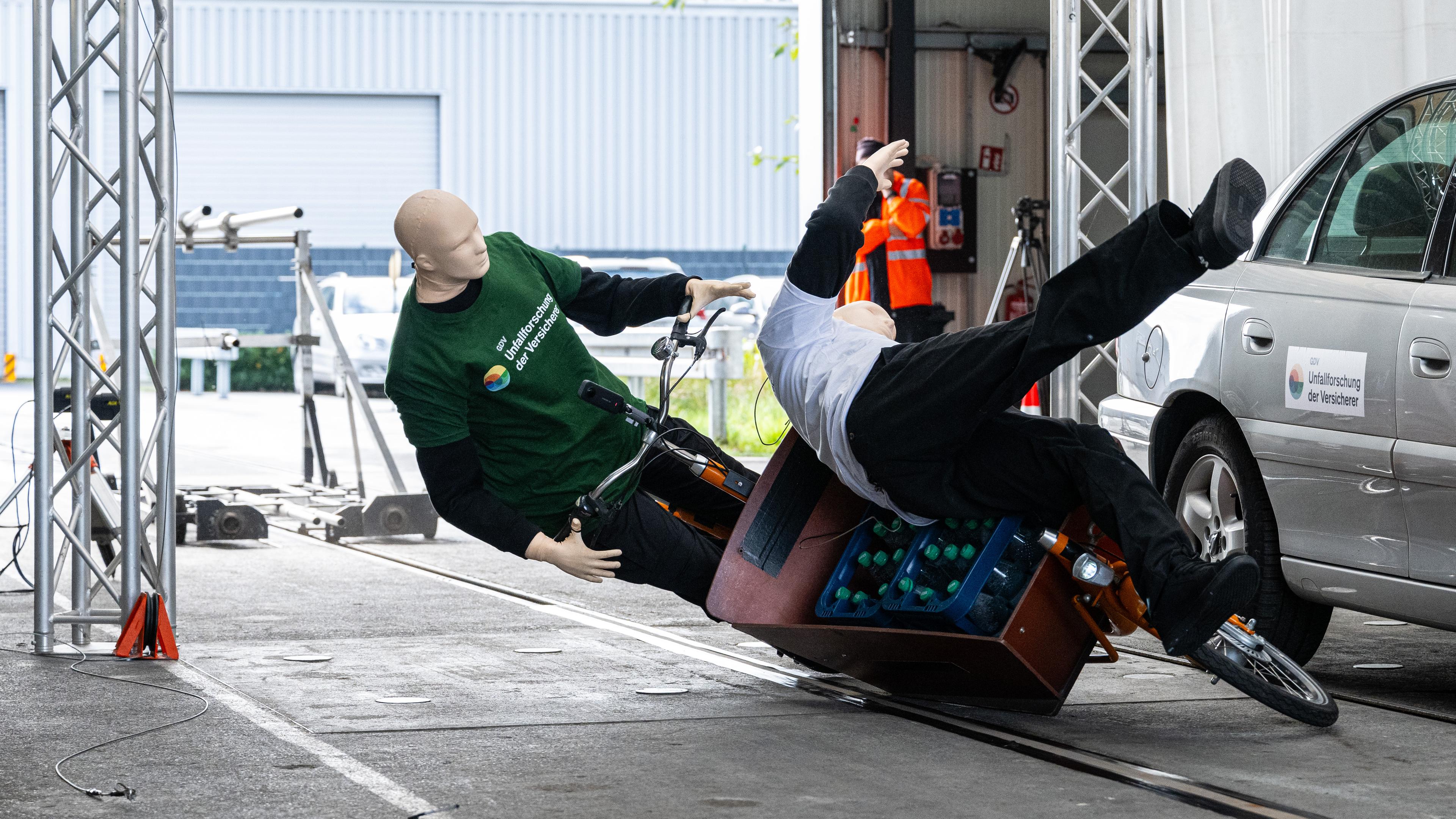 Bei einem Crashtest stoßen ein Lastenfahrrad und ein Fußgänger im Rahmen zusammen