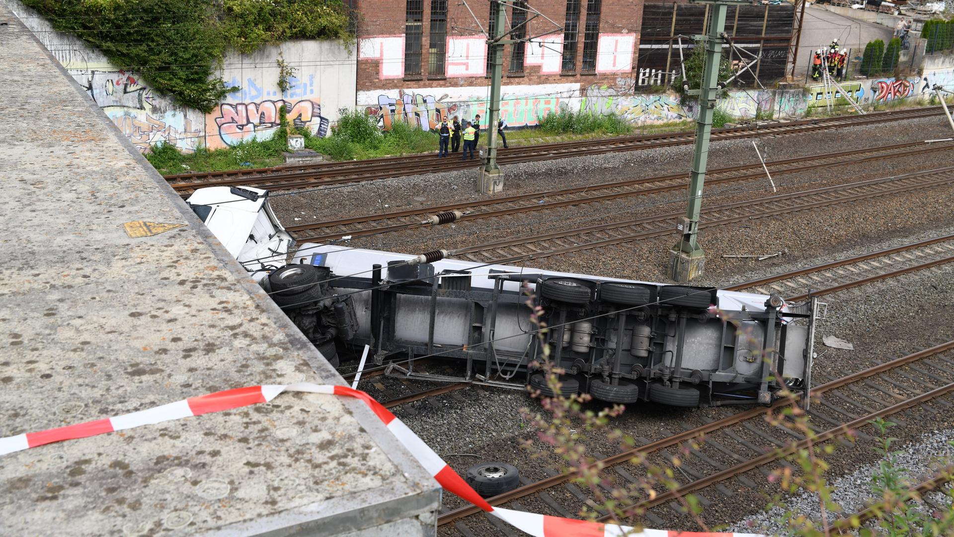 Nordrhein-Westfalen, Kerpen: Ein Lastwagen liegt nach dem Sturz von einer Brücke auf Bahngleisen.
