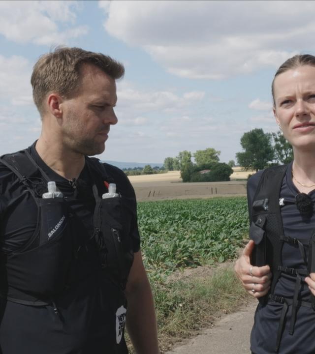 Frau und Mann mit schwarzen Laufwesten im Bild
