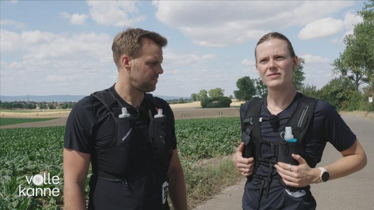 Frau und Mann mit schwarzen Laufwesten im Bild