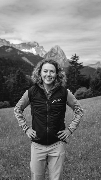 Die Ex-Biathletin Laura Dahlmeier vor einem Bergpanorama. Das Foto ist schwarzweiß.