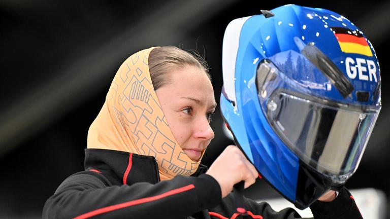 Die deutsche Bobfahrerin Laura Nolte bereitet sich auf das Rennen vor und zieht ihren Helm an