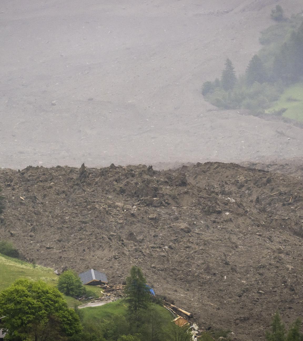 Ein Dorf bedeckt von Schutt und Schlamm durch eine Lawine