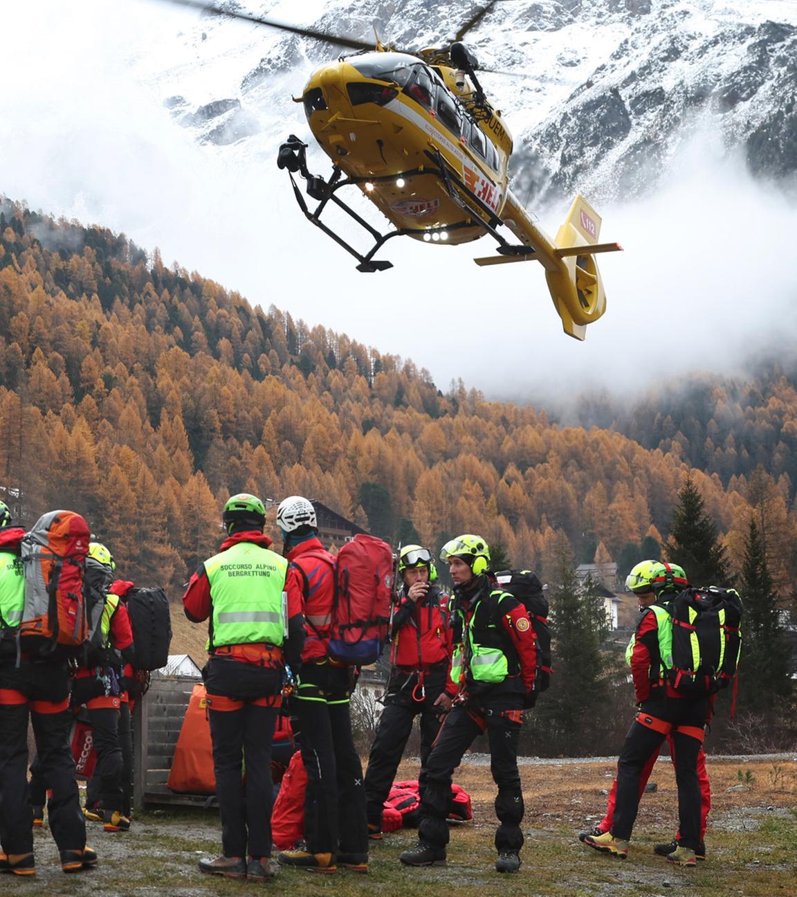  Ein Hubschrauber der Bergrettung landet vor Bergrettern. Nach dem Tod von mindestens drei deutschen Bergsteigern bei einem Lawinenunglück am 02.11.2025 in Südtirol ist die Suche nach zwei Vermissten wieder aufgenommen worden.