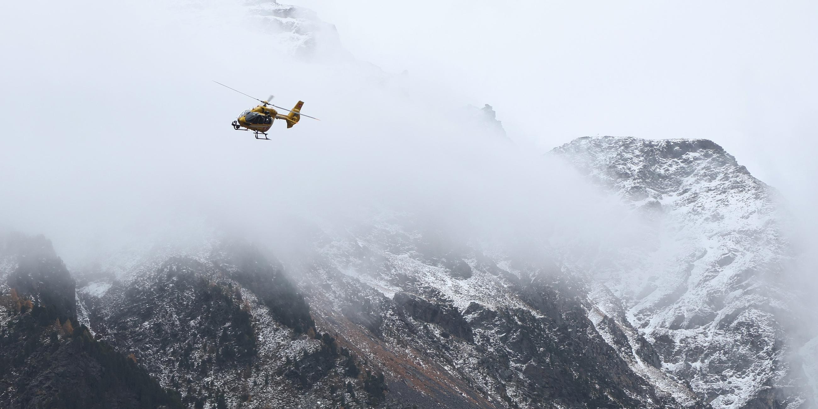  Ein Hubschrauber der Bergrettung landet vor Bergrettern. Nach dem Tod von mindestens drei deutschen Bergsteigern bei einem Lawinenunglück am 02.11.2025 in Südtirol ist die Suche nach zwei Vermissten wieder aufgenommen worden.
