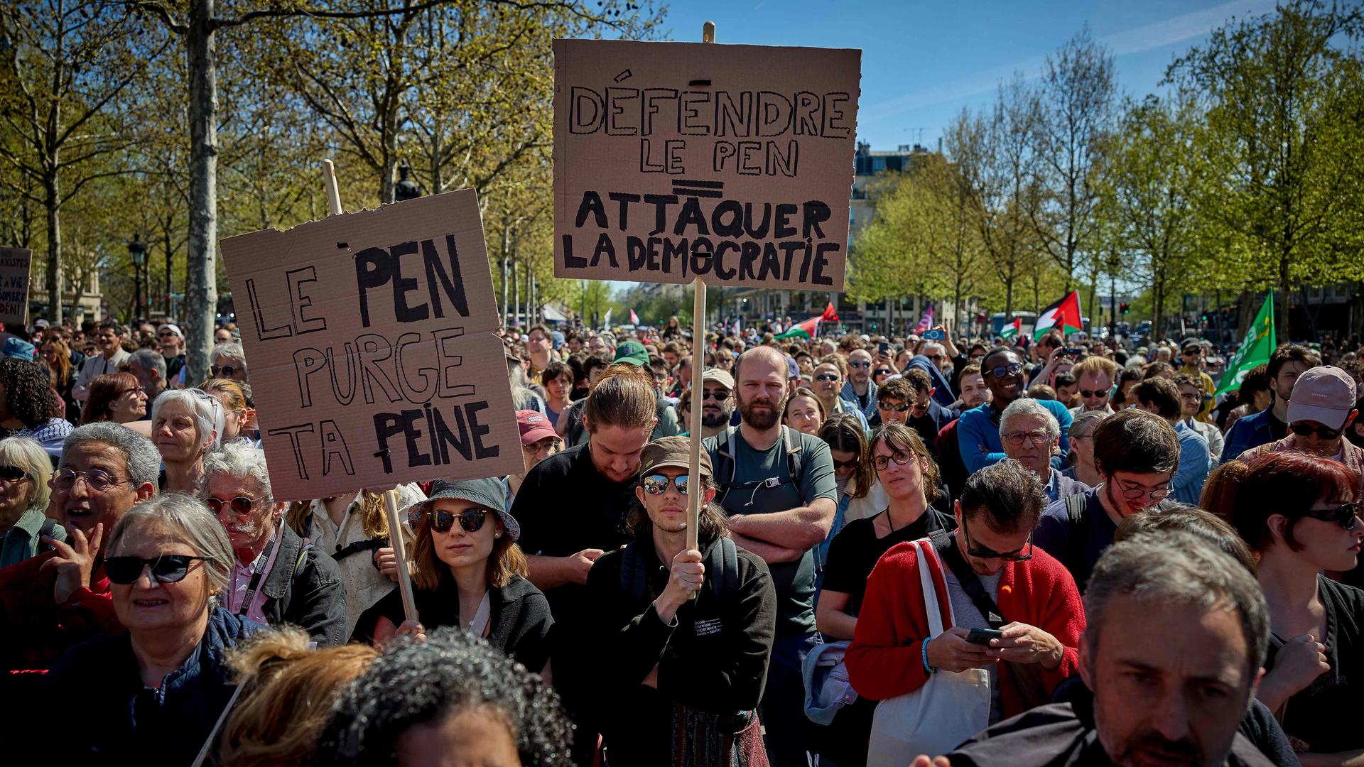 Demonstranten halten Plakate mit der Aufschrift "Le Pen, verbüße deine Strafe" und "Le Pen verteidigen = Demokratie angreifen" hoch.