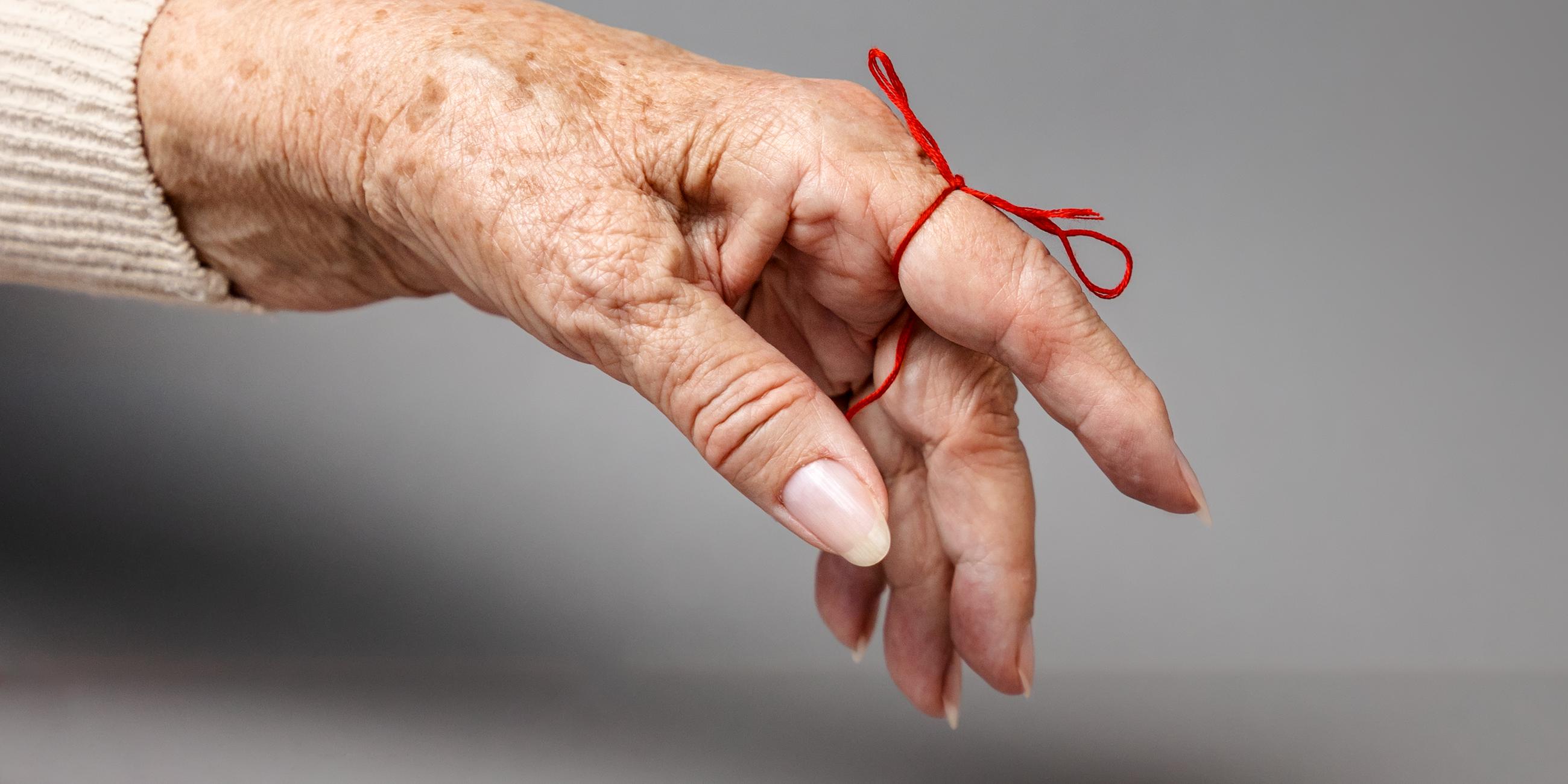 Ausgestreckter Finger mit einer Schleife zur Erinnerung daran. 