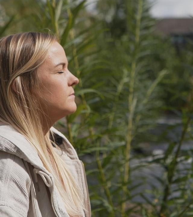 Protagonisten steht an einem See und hat die Augen zu