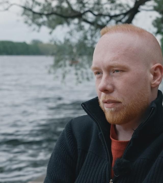 Niklas Schütz draußen in Gedanken an einem Fluß.