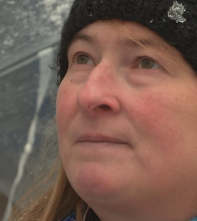 Eine Frau mit Regenschirm in Gedanken.