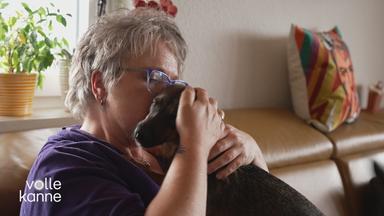 Frau nach einer Krebserkrankung kuschelt mit ihrem Hund.