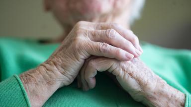 Seniorin faltet ihre Hände