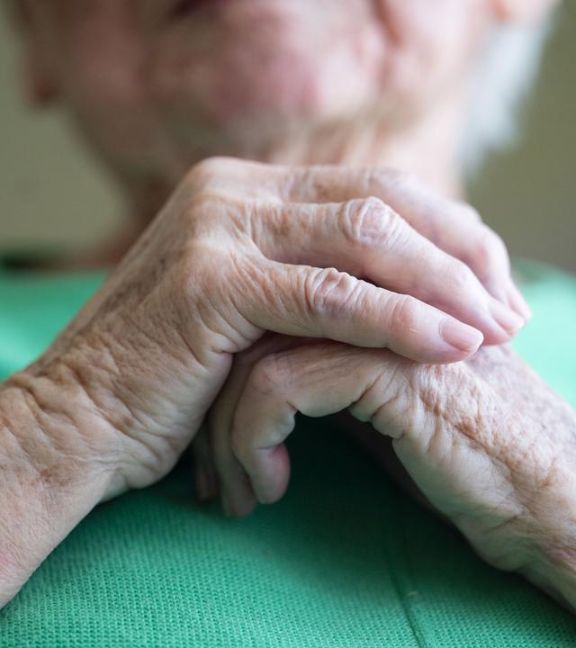 Seniorin faltet ihre Hände