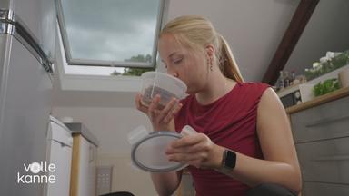Frau riecht an Lebensmittel in einer Dose, um zu prüfen, ob sie das Essen sicher gelagert hat.