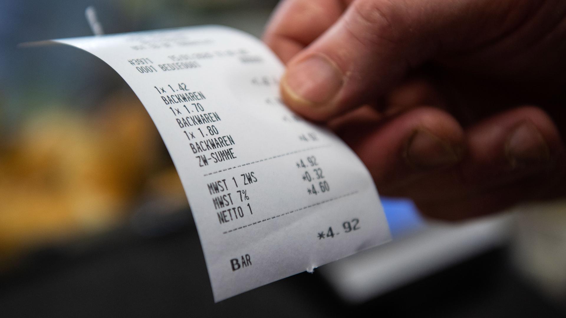 Symbolbild: person haelt kassenzettel