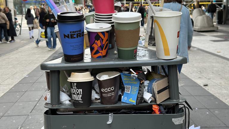 Schweden, Stockholm: Alte Einwegkaffeebecher stapeln sich auf einem Mülleimer in der Fußgängerzone von Stockholm.
