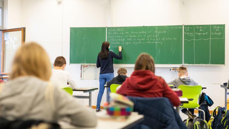 Schülerinnen und Schüler einer fünften Klasse der Johanniter Realschule Heitersheim sitzen während dem Unterricht in ihrem Klassenzimmer.