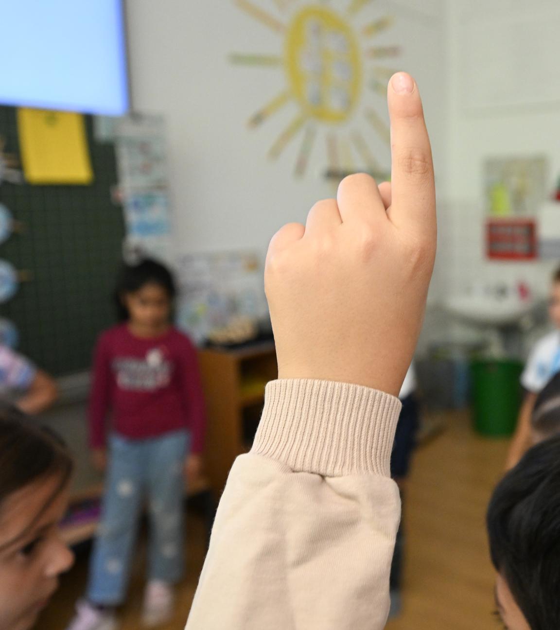 Baden-Württemberg, Stuttgart: Schüler einer Grundschule melden sich bei einer Schulstunde.