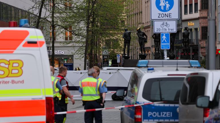 Einsatzkräfte stehen am Eingang der Grimmaischen Straße. In Leipzig ist ein Auto in mehrere Menschen gefahren. (zu dpa: «Staatsanwaltschaft ermittelt wegen Mordes»)