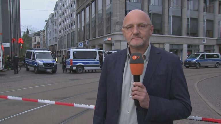 Thomas Bärsch in der Leipziger Fußgängerzone. Im Hintergrund stehen Polizeiwägen.