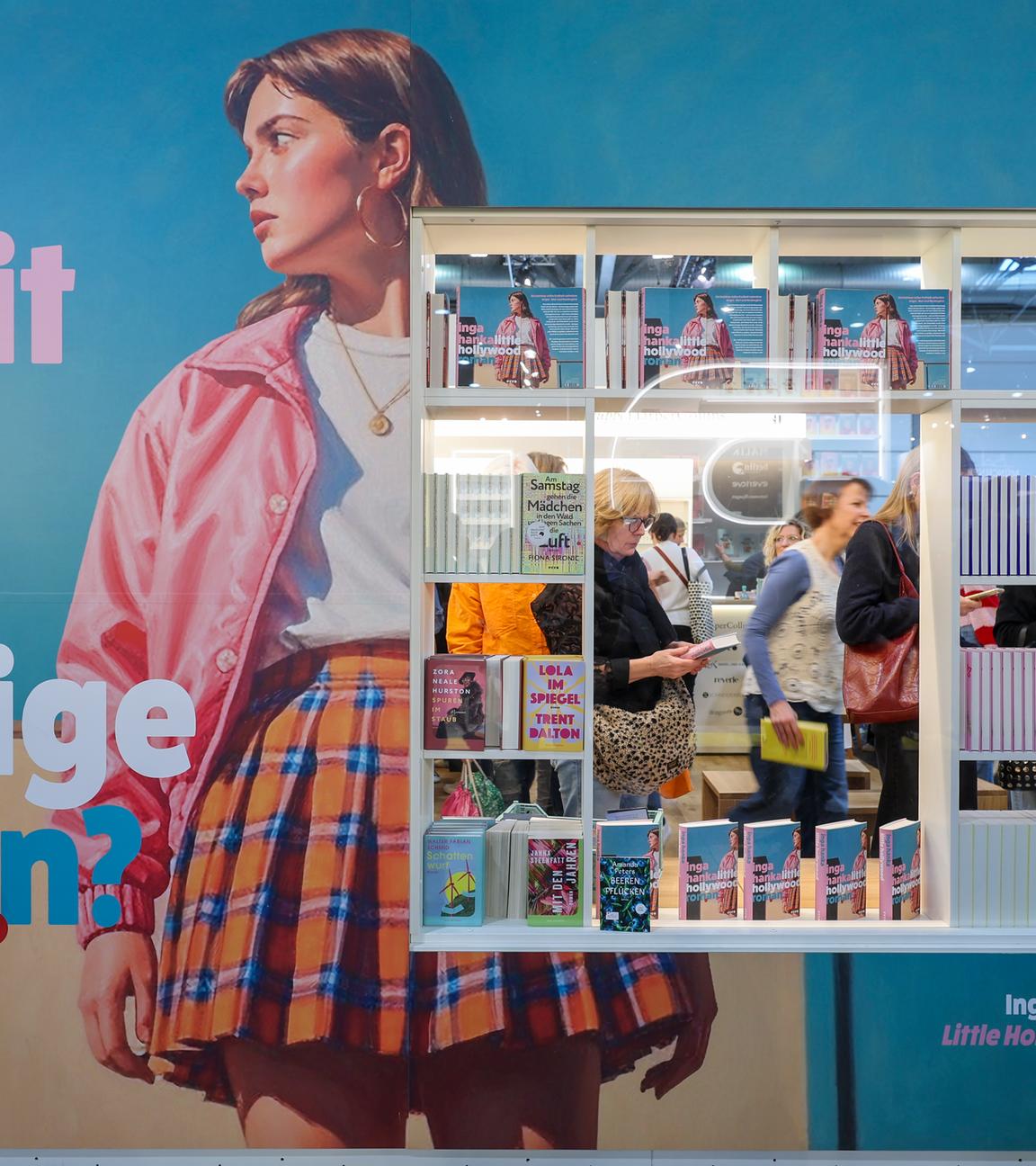 Besucher sind durch ein Schaufenster eines Standes auf der Leipziger Buchmesse zu sehen