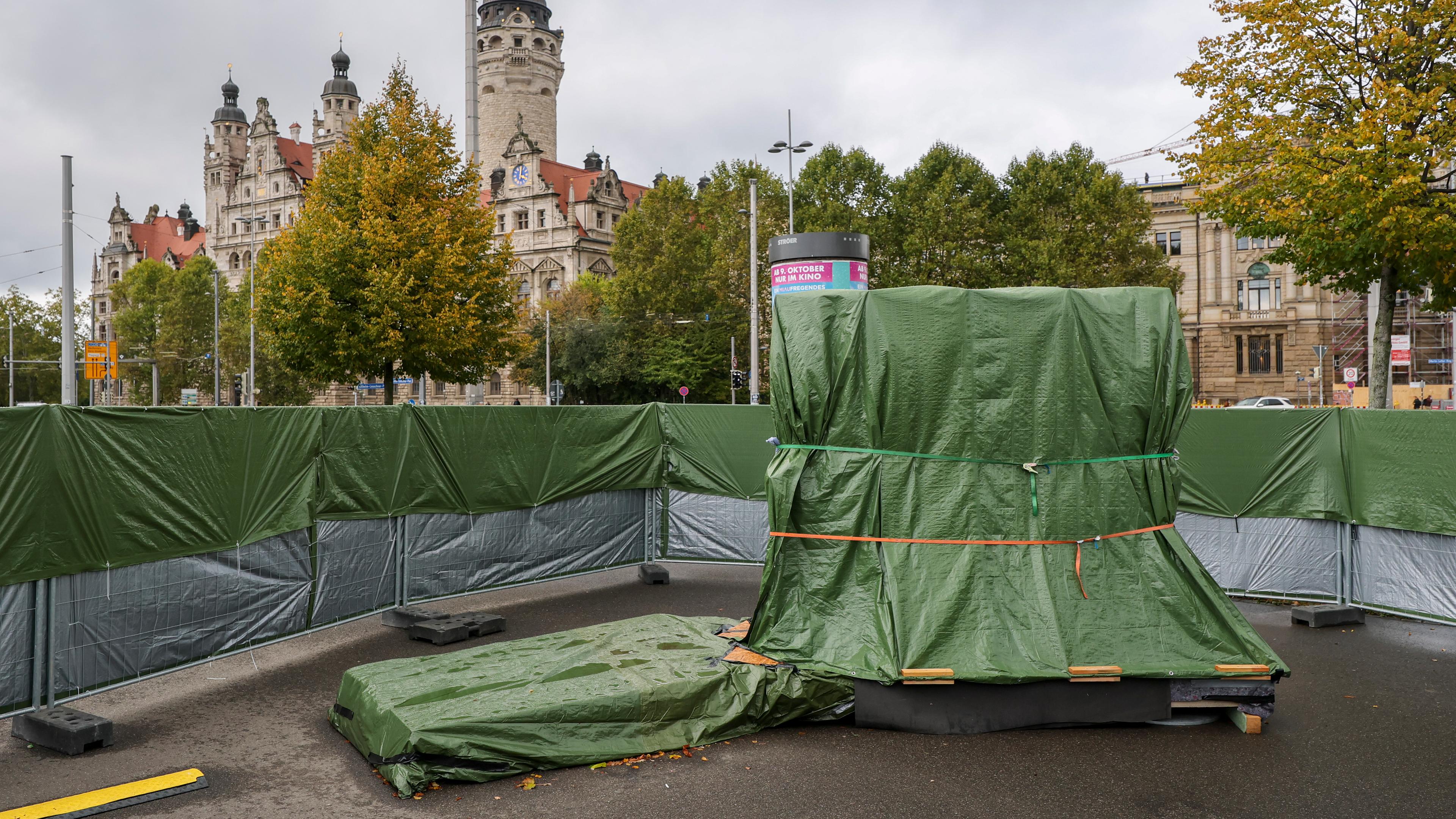 Der mit grünen Planen verhüllte Grundstein für das Freiheits- und Einheitsdenkmal steht auf dem Wilhelm-Leuschner-Platz. Zum 36. Jahrestag der friedlichen Revolution soll am 9. Oktober auf diesem Platz der Grundstein für das lange geplante Freiheits- und Einheitsdenkmal gelegt werden. Für rund fünf Millionen Euro soll ein dezentrales Denkmal aus 50 weißen Skulpturen entstehen.