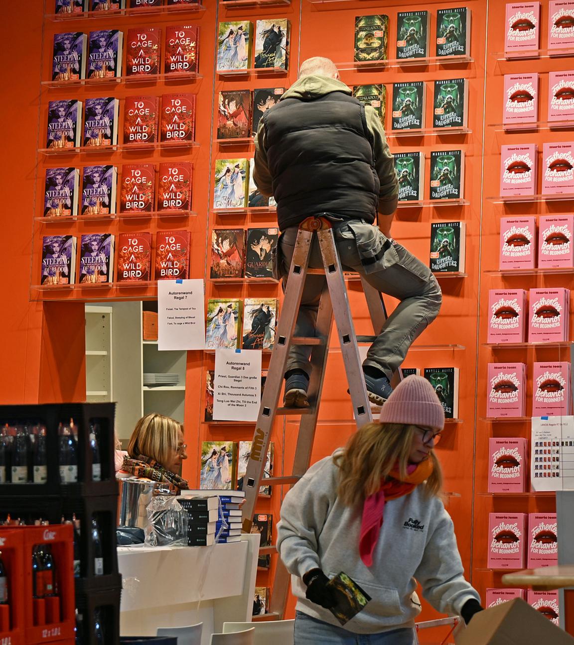 Ein Mitarbeiter räumt ein Regal am Stand des Verlages Droemer Knaur auf der Leipziger Buchmesse ein.
