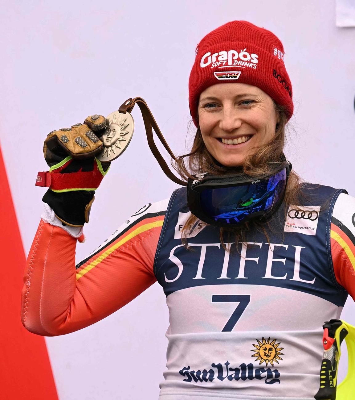 Lena Dürr hält ihre Silbermedaille und Ski in der Hand.
