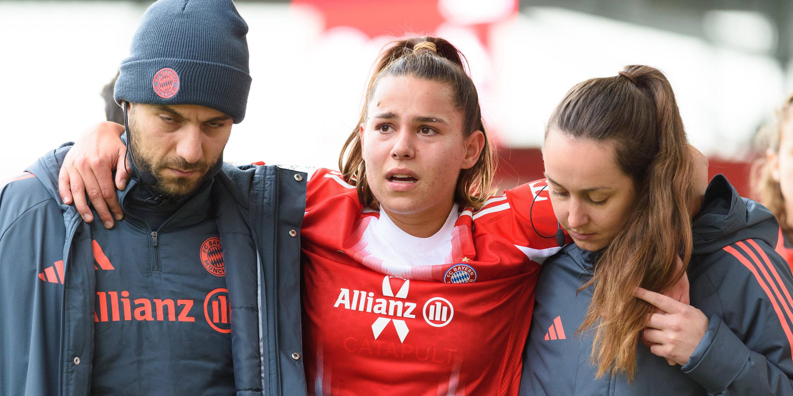 Die verletzte Lena Oberdorf (08) vom FC Bayern München wird gestützt in die Umkleidekabine gebracht. 