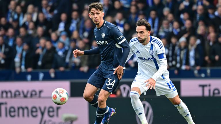 In der Zweitligapartie des VfL Bochum gegen den FC Schalke 04 wird der Ballführende Bochumer Cajetan Lenz von Schalker Kenan Karaman von hinten bedrängt 