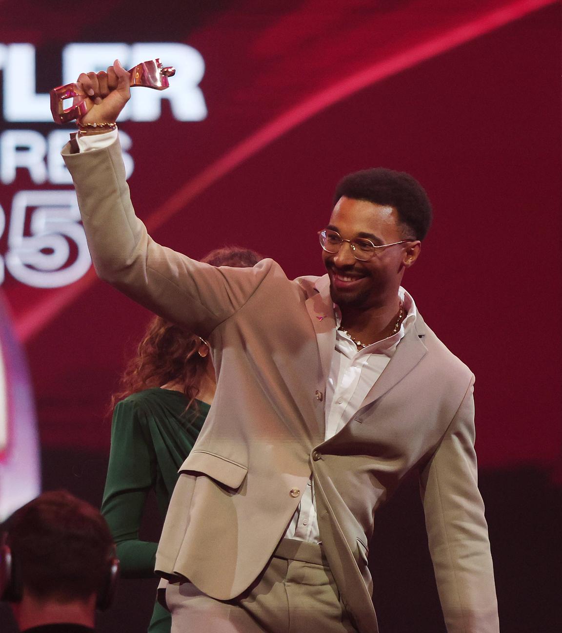 Leo Neugebauer hält den Preis für die Auszeichnung "Sportler des Jahres" in die Luft