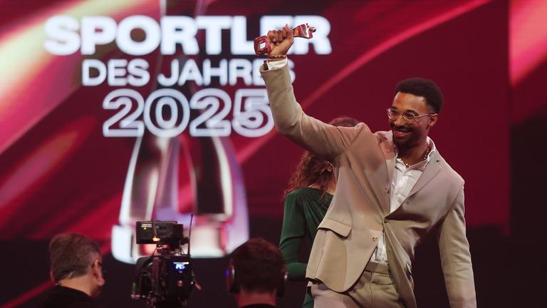 Leo Neugebauer hält den Preis für die Auszeichnung "Sportler des Jahres" in die Luft