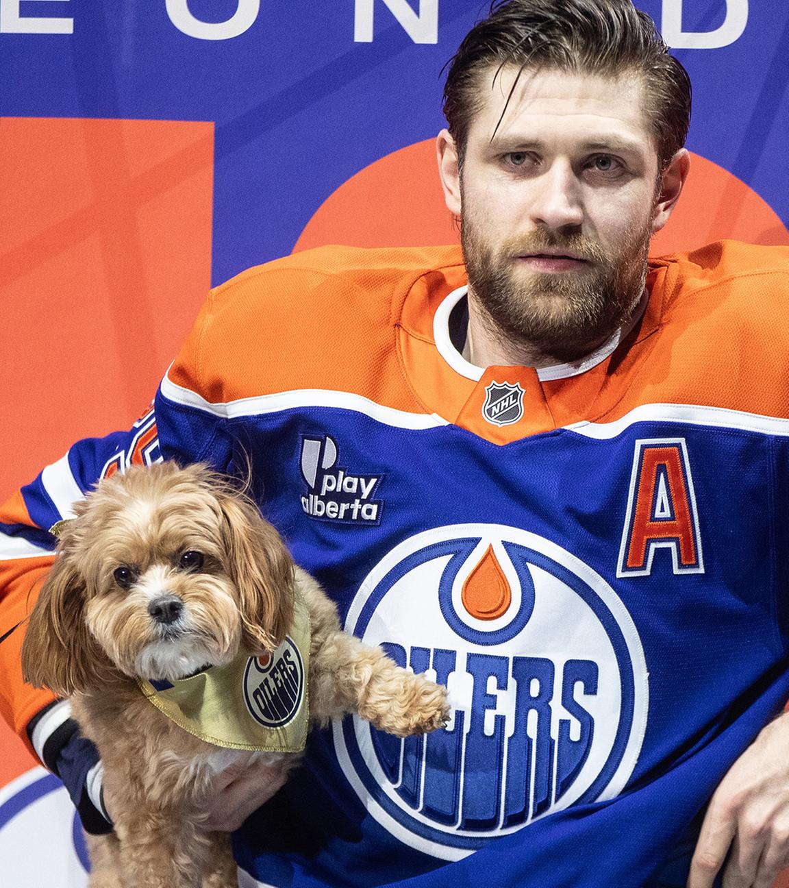 Leon Draisaitl von den Edmonton Oilers steht vor dem Spiel mit seinem Hund vor der Ehrung für seinen 1000. Punkt.