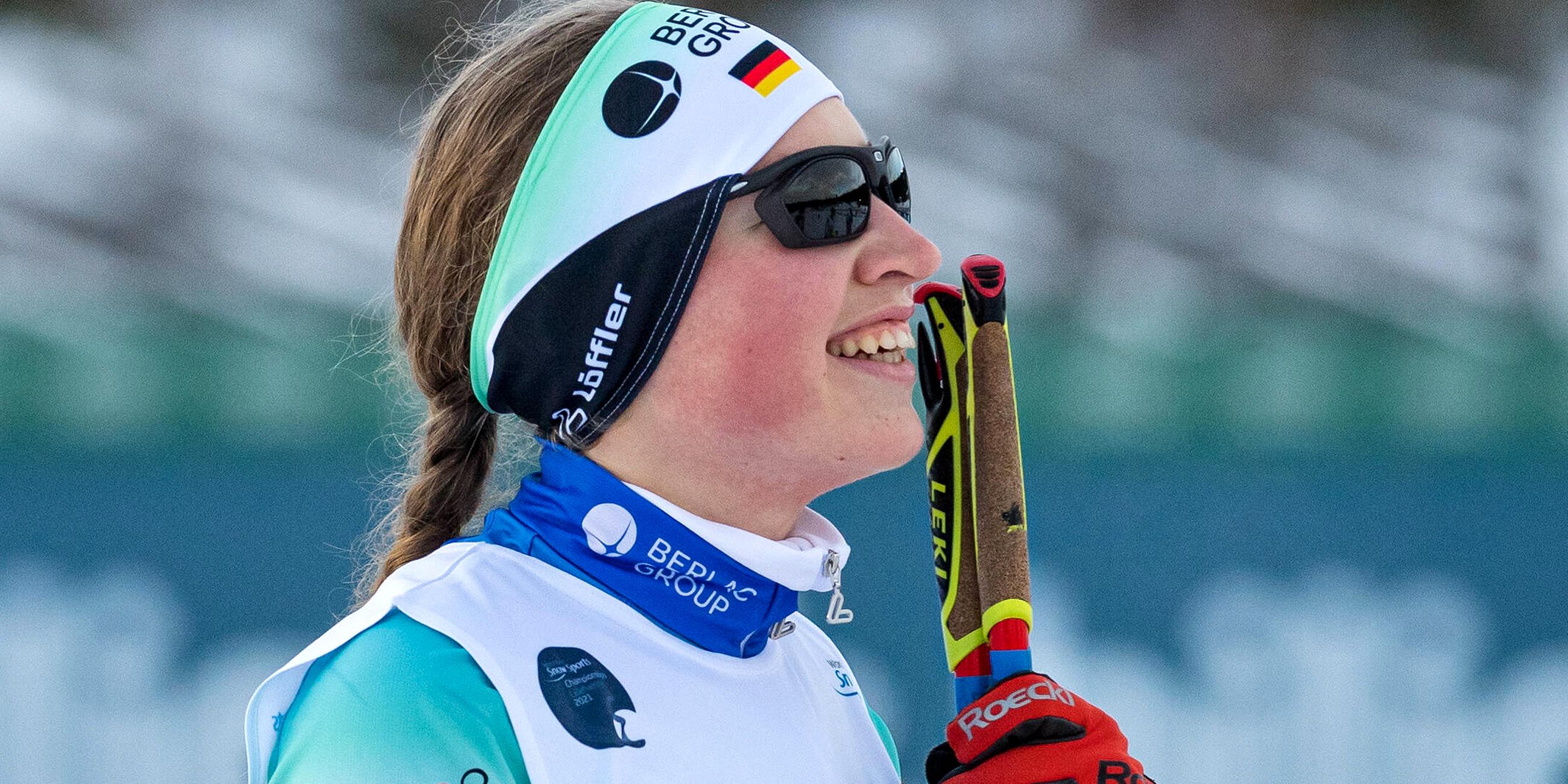 Leonie Walter im Profil, sie trägt eine Sonnenbrille und lächelt.