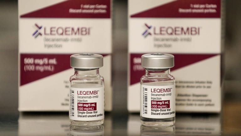 Zwei Packungen des Medikaments Leqembi mit zwei Ampullen davor.